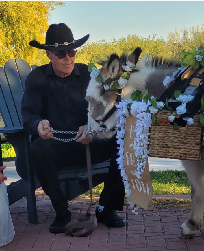 Bruce Dunbar with a flower-adorned burro